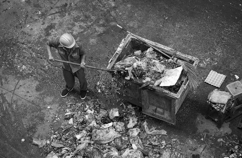 Construction site with waste materials being cleared by professionals.